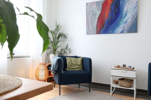 Raum, in dem ein blauer Sessel vor einem bunten Bild zu sehen ist